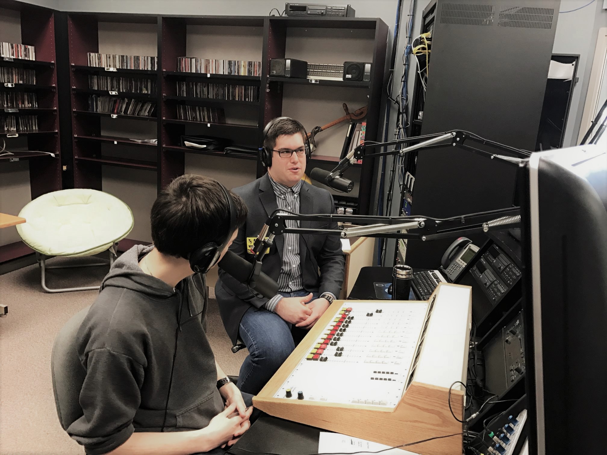 two people seated at a mixing desk